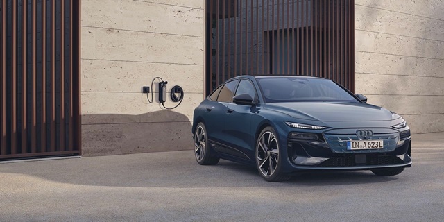 Blauer Audi A6 Sportback e-tron parkt an einer Wallbox.