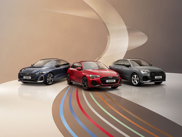 Drei Audi-Fahrzeuge in Blau, Rot und Grau stehen nebeneinander vor einem hellen Hintergrund mit geschwungenen Linien.