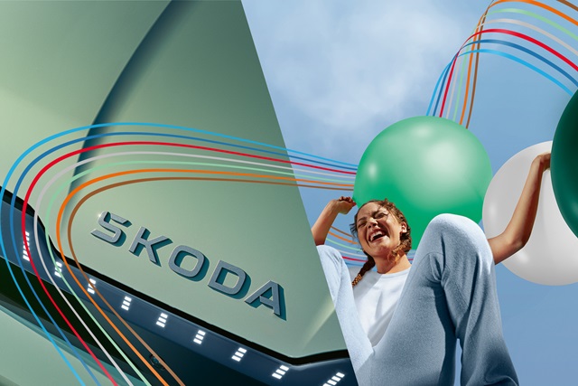 Nahaufnahme eines Skoda-Logos mit einer Frau, die einen grünen Ballon hält.