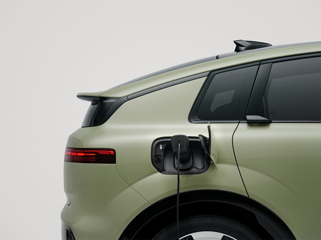Hellgrüner Audi A2 e-tron in Detailansicht beim Laden vor einem weißen Hintergrund 