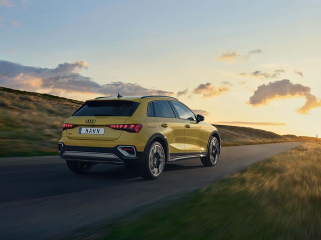 Gelber Audi A3 Allstreet von hinten auf einer Landstraße bei Sonnenuntergang