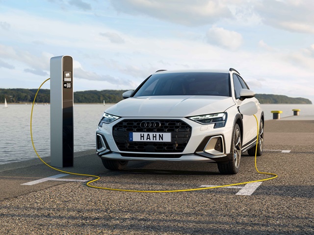 Weißer Audi A3 allstreet tfsi e an einer Ladestation am Hafen mit gelbem Ladekabel