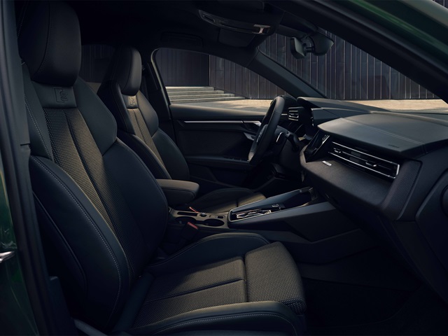 Innenraum eines Audi A3 Sportback mit zwei Vordersitzen, Lenkrad und Mittelkonsole in dunklem Design