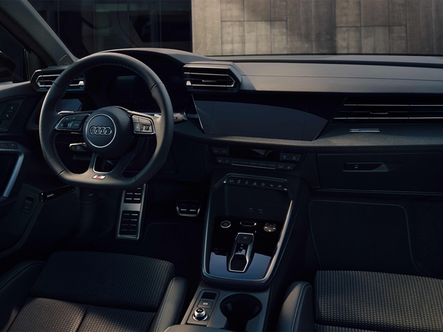 Innenraum eines Audi A3 Sportback mit Lenkrad, digitalem Cockpit und Mittelkonsole mit Schaltwippe und Bedienelementen