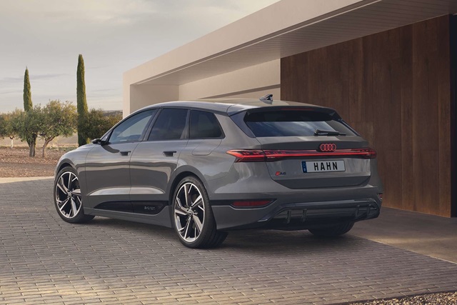 Heckansicht eines grauen Audi A6 e-tron Avant mit großen Felgen vor modernem Gebäude