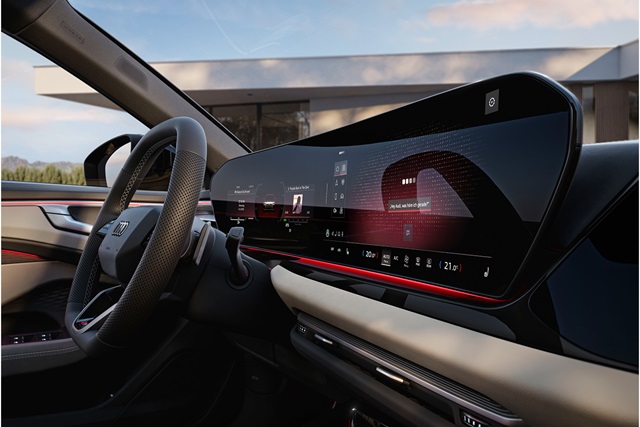 Innenraum eines Audi A6 Avant mit digitalem Kombiinstrument und großem Touchscreen-Display, schwarzes Lenkrad mit perforiertem Leder und roter Ambientebeleuchtung