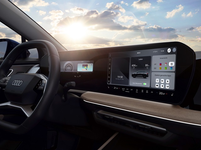 Innenraum des Audi Q4 e-tron mit digitalem Kombiinstrument, großem Touchscreen in der Mittelkonsole und Holzdekor auf dem Armaturenbrett.