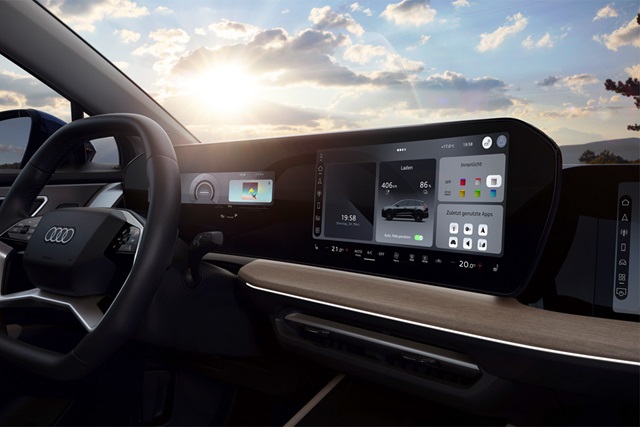 Innenraum des Audi Q4 e-tron mit digitalem Kombiinstrument, großem Touchscreen in der Mittelkonsole und Holzdekor auf dem Armaturenbrett.