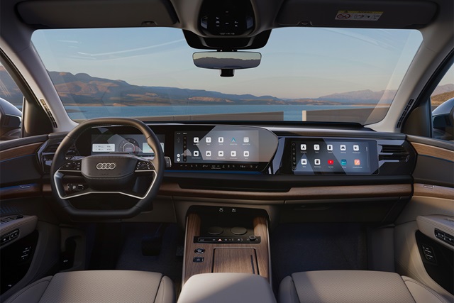 Cockpit eines Audi Q7 mit Digital Cockpit, fahrerzentriertem Touchscreen sowie Beifahrerdisplay und Holzapplikationen auf der Mittelkonsole