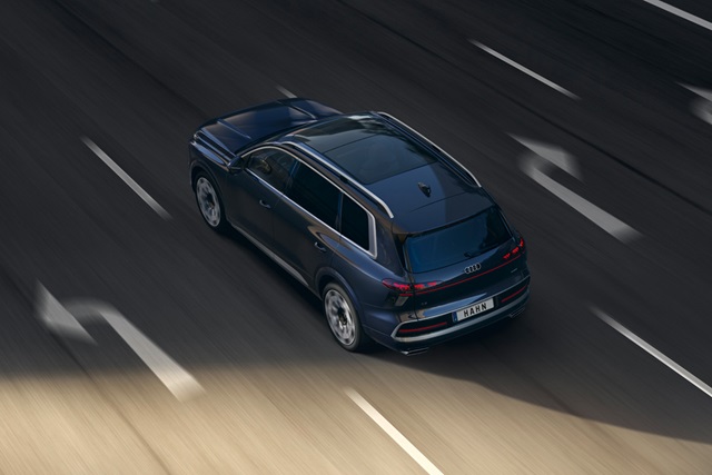 Blaue Audi Q9 SUV-Heckansicht mit Dachantenne und Rückfahrkamera auf mehrspuriger Straße