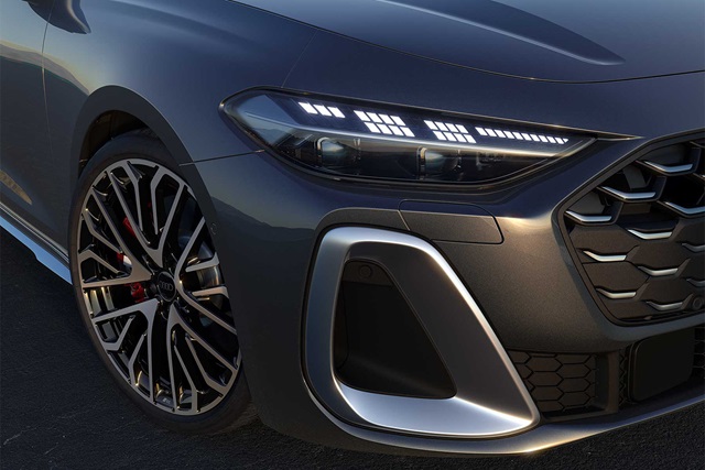 Nahaufnahme der Frontpartie eines grauen Audi S5 Avant mit markantem Scheinwerfer, großem Wabengrill und sportlichem Leichtmetallrad