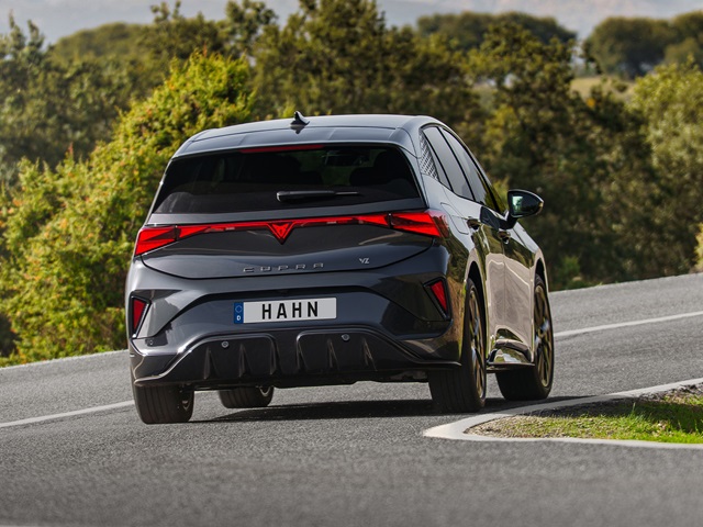 CUPRA Born VZ in Dunkelgrau aus der Rückansicht auf einer Landstraße mit sichtbarem Schriftzug und markanten Rückleuchten