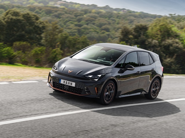 CUPRA Born VZ in dunkelgrau aus seitlicher Perspektive auf Landstraße mit sichtbarem Schriftzug 'HAHN' auf dem Kennzeichen.