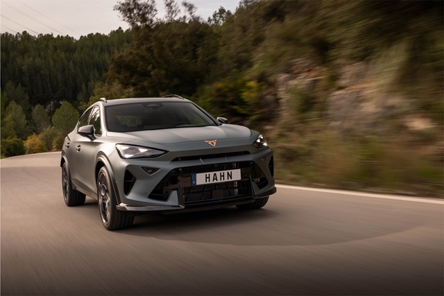 Cupra Formentor VZ5 in blauer Lackierung fährt auf einer kurvigen Landstraße mit bewaldeter Umgebung