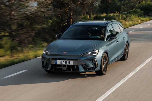 Cupra Leon Sportstourer VZ Extreme in mattem Blau fährt auf einer Landstraße mit Wald im Hintergrund