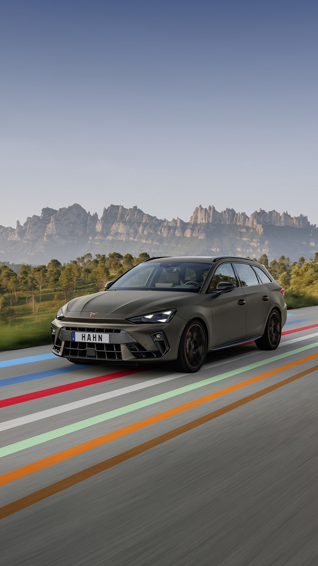 Cupra Leon Sportstourer VZ Extreme in braun mit sportlicher Frontansicht vor Bergkulisse und mehrfarbigen Fahrbahnmarkierungen