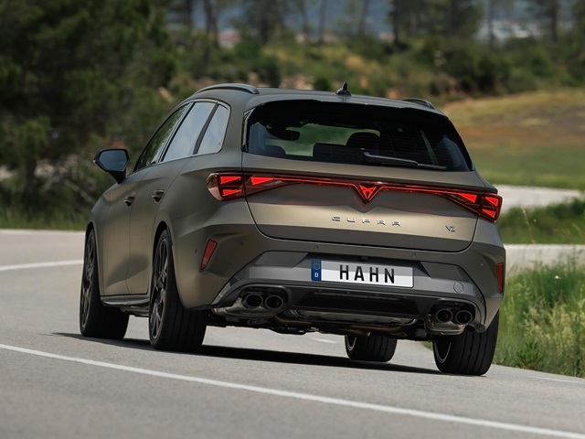 Heckansicht eines braunen CUPRA Leon Sportstourer VZ mit vier Auspuffendrohren und deutschem Kennzeichen 'HAHN' auf einer Landstraße