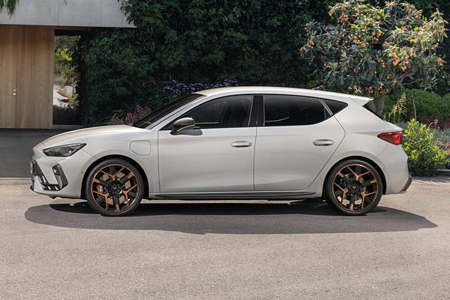 Seitenansicht eines eleganten weißen CUPRA Leon mit schwarzen und bronzefarbenen Felgen im Freien.