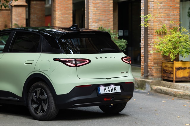 Mintgrüner Geely E2 mit dunklem Dach und markanten Rückleuchten aus der Rückansicht, Kennzeichen mit dem Schriftzug 'HAHN'
