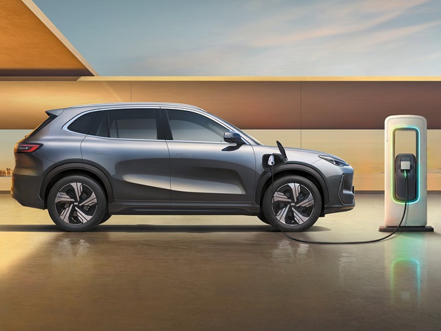 Grauer Geely E5 in Seitenansicht an einer Ladesäule in moderner Umgebung