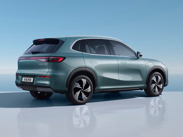 Geely E5 SUV in grüner Seiten- und Heckansicht mit schwarzem Dach und modernen Leichtmetallrädern auf spiegelnder Oberfläche