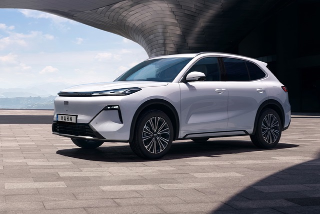 Weiße Seitenansicht des Geely Starray EM-i SUV mit markantem Frontdesign und modernen Felgen vor futuristischem Gebäude