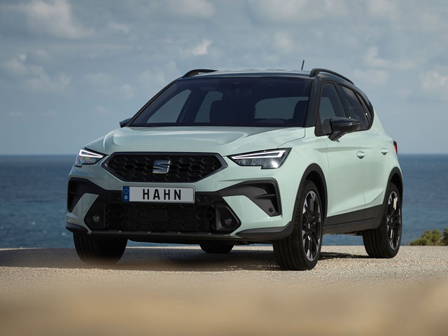 SEAT Arona SUV in Grau von vorne mit schwarzem Kühlergrill und Dach, geparkt vor Meereshintergrund