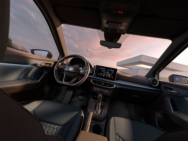 Innenraum des grauen SEAT Arona SUV mit multifunktionalem Lenkrad, digitalem Kombiinstrument und großem Touchscreen in der Mittelkonsole