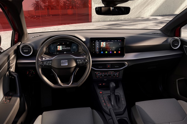 Innenraum des roten SEAT Ibiza mit multifunktionalem Lenkrad, digitalem Kombiinstrument und großem Touchscreen in der Mittelkonsole