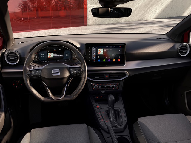 Innenraum des roten SEAT Ibiza mit digitalem Cockpit, großem Touchscreen in der Mittelkonsole, Lederlenkrad mit Multifunktionstasten und Stoffpolstersitzen