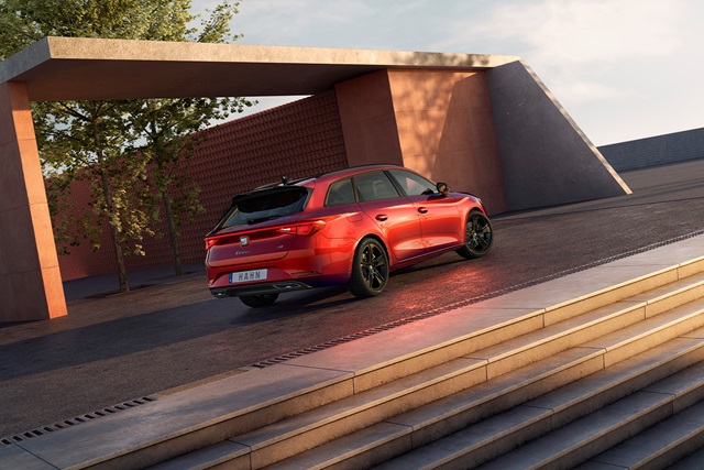 Roter SEAT Leon Sportstourer FR Black Edition von hinten rechts vor moderner Architektur mit schwarzen Felgen