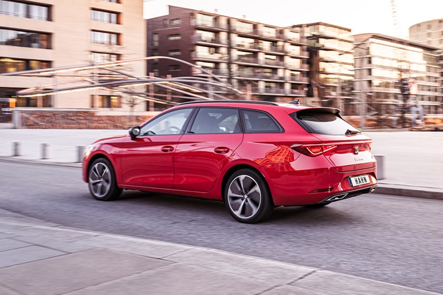Roter SEAT Leon Sportstourer in Seitenansicht auf urbaner Straße vor modernen Wohngebäuden
