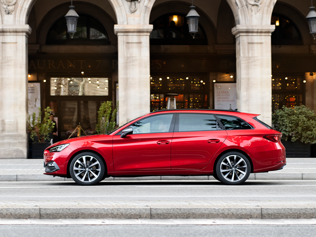 Roter SEAT Leon Sportstourer in Seitenansicht vor einem Gebäude mit Arkaden und Pflanzen
