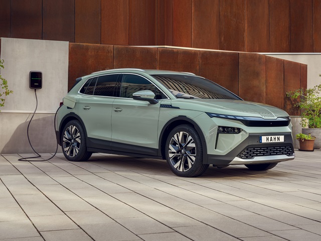 Skoda Elroq Elektro-SUV in Seitenansicht an Ladestation mit Kabel in moderner urbaner Umgebung