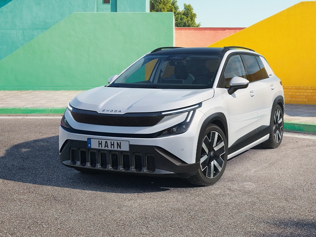 Frontansicht eines weißen Škoda Epiq SUV vor einer farbigen Wand mit grünen, roten und gelben Flächen