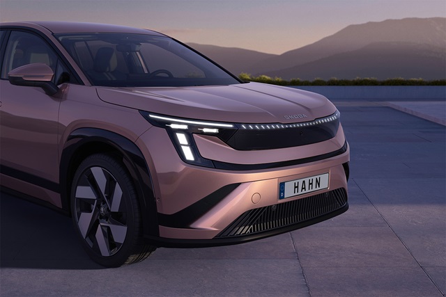 Vorderansicht des Škoda Peaq mit markanten LED-Scheinwerfern vor Bergkulisse bei Dämmerung.