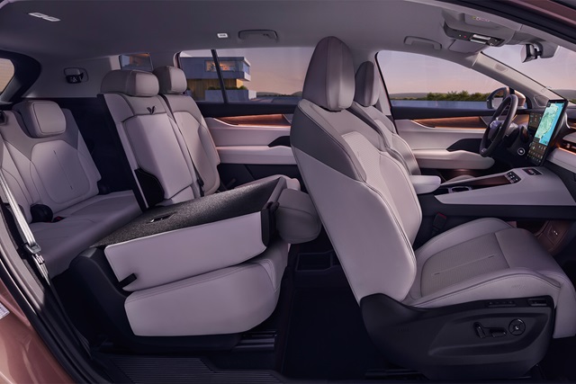 Innenraum des Škoda Peaq mit sieben hellgrauen Sitzen, umgeklapptem Rücksitz und modernem Armaturenbrett mit großem Display