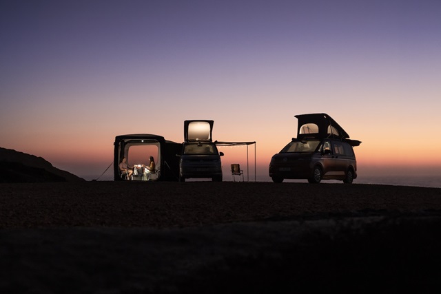 Zwei Volkswagen California Modelle im Sonnenuntergang mit Aufstelldach.