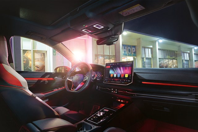 Innenraum eines roten VW Golf GTI mit beleuchtetem Armaturenbrett und digitalem Display 