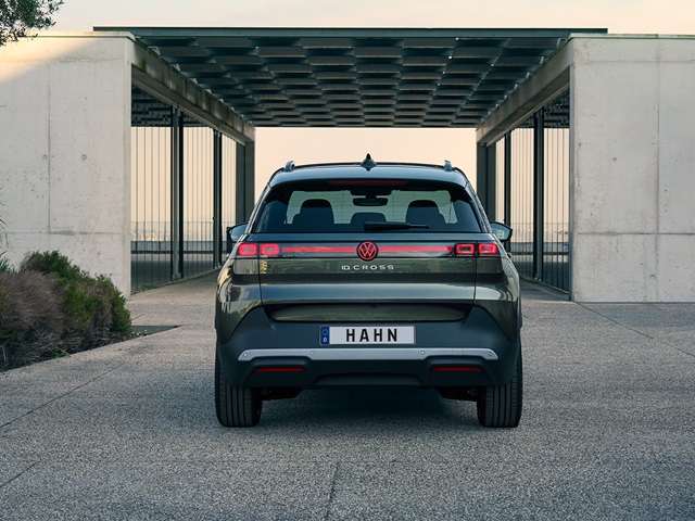 Heckansicht eines grünen VW ID. Cross mit dem Kennzeichen 'HAHN' vor einer modernen, offenen Betonstruktur mit Gitterelementen