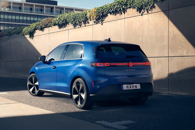 Blauer VW ID. Polo von hinten mit auffälligen Rückleuchten, geparkt vor einer Betonwand mit Pflanzen am oberen Rand