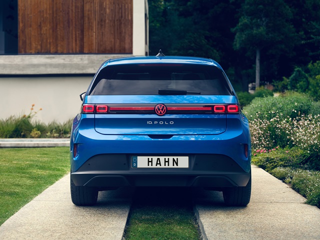 Blaue Heckansicht eines VW ID. Polo mit dem Kennzeichen 'HAHN' auf einem Weg vor einem modernen Haus