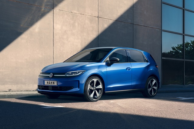 Seitliche Ansicht eines blauen Volkswagen ID. Polo vor einer Betonwand und einem Glasfenster