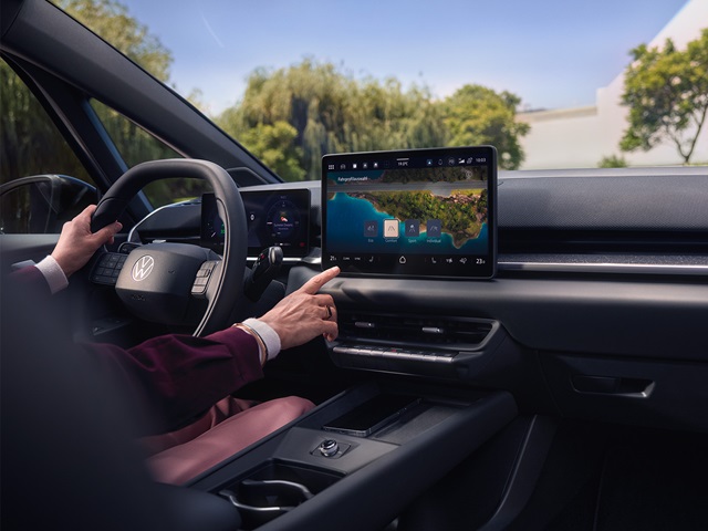 Innenraum des VW ID.3 Neo mit digitalem Cockpit, großem Touchscreen in der Mittelkonsole und Fahrerhand am Lenkrad sowie am Bildschirm
