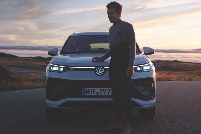 Der Volkswagen Tayron in Frontansicht mit Leuchtband, Scheinwerfern und beleuchtetem VW Logo