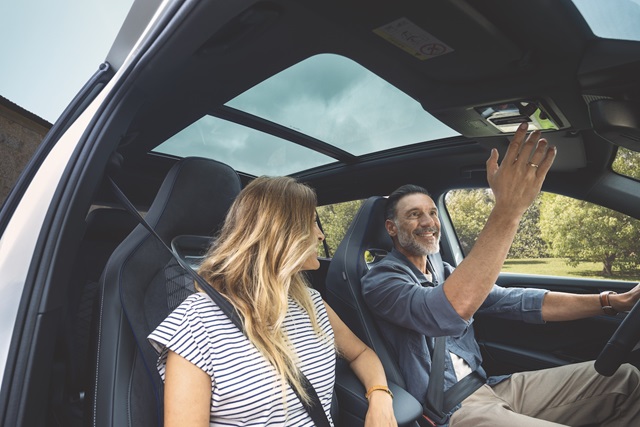 Zwei Personen im Volkswagen Tayron, die das Panoramadach bedienen 